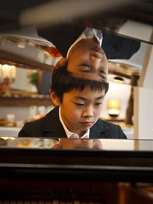 Enfant au piano pendant un cours Piano Académie